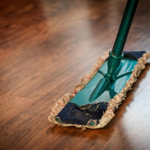 A detailed view of a mop cleaning a wooden floor, showing texture and pattern.