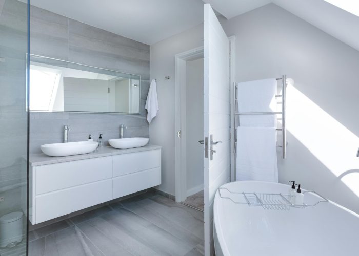 Sleek contemporary bathroom with bathtub and twin sinks, showcasing minimalist design and luxury.